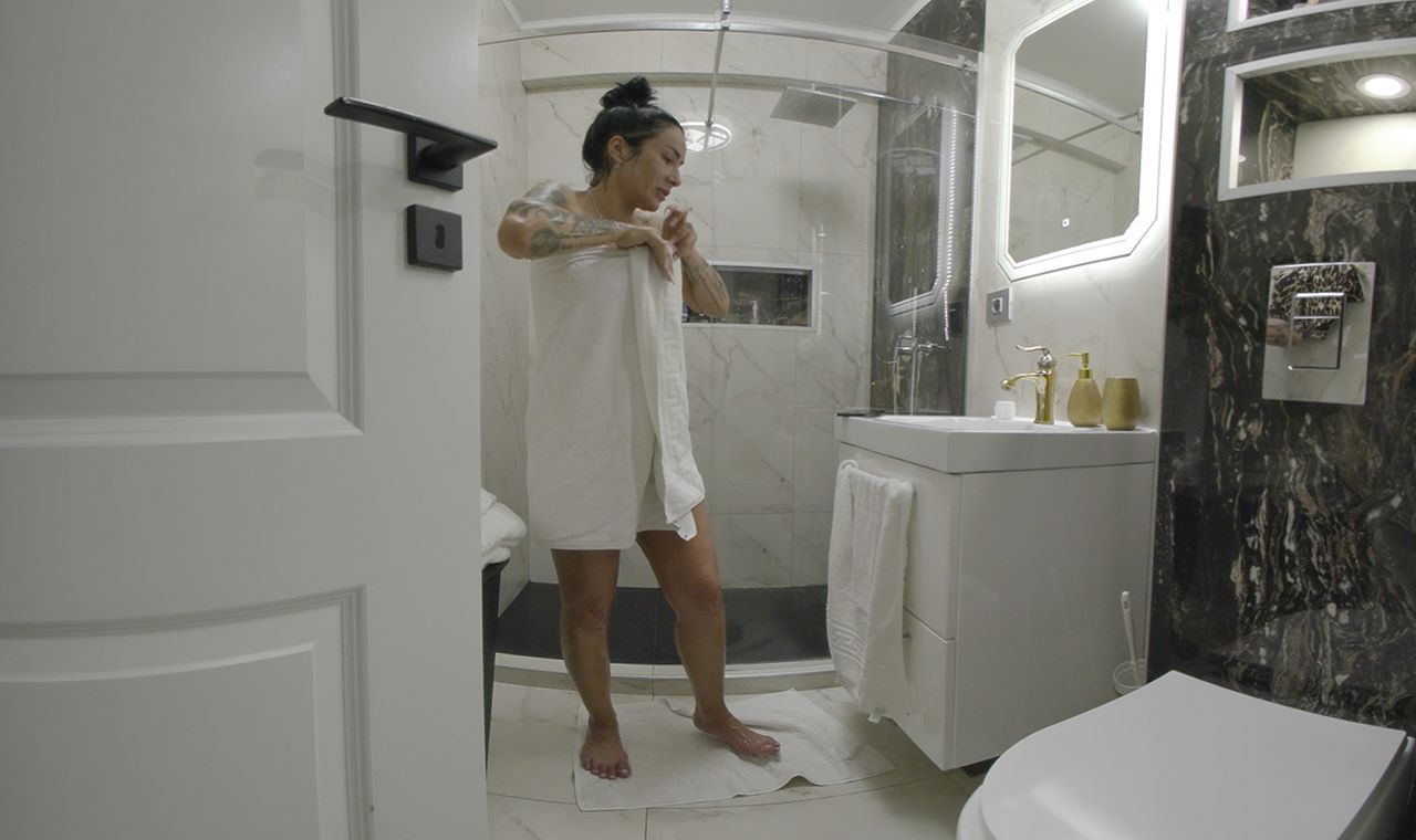 Mistress Kennya poses in a shower during a BDSM vacation fantasy filmed in 4K VR POV style for HouseOfLust.