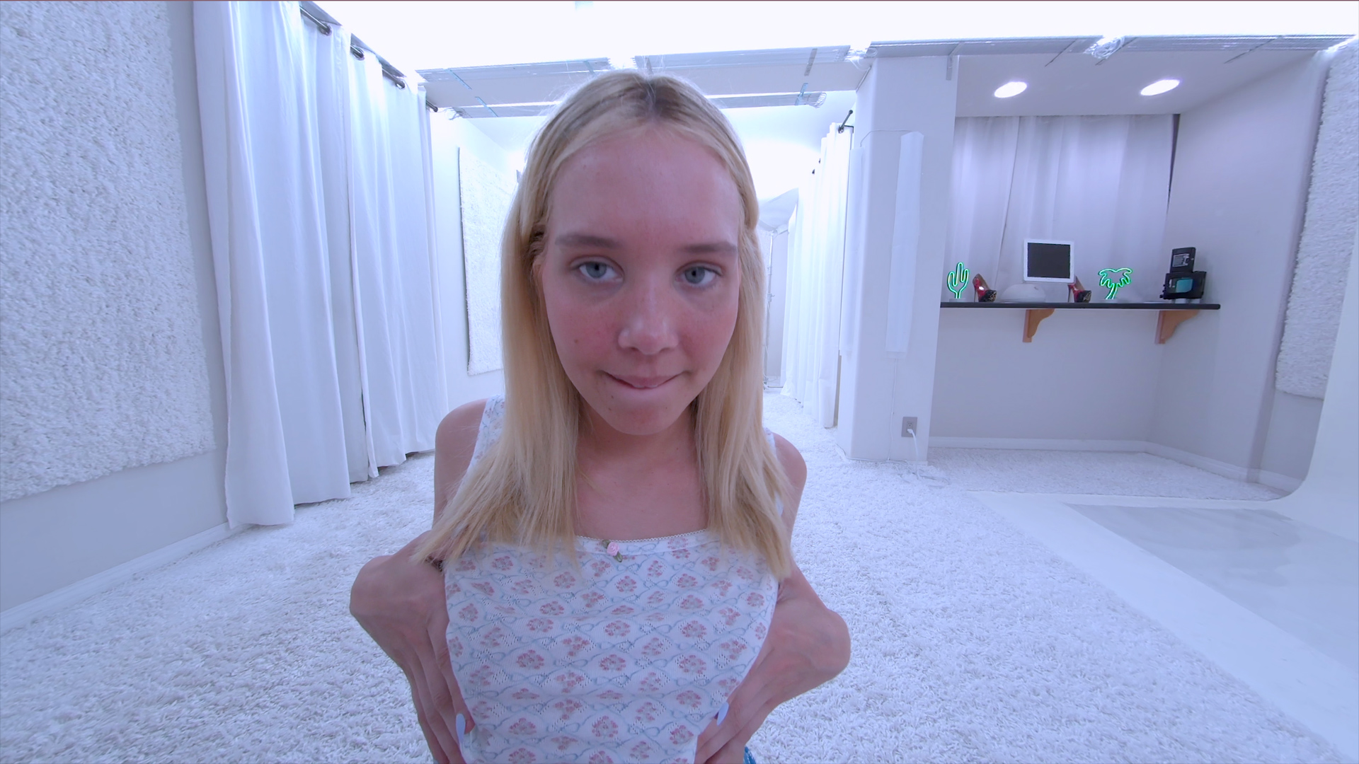 Blonde Sophia Sterling strips in a white studio during a casting scene filmed in 4K VR POV.